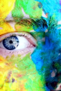 Close-up of a person with colorful rainbow face paint, symbolizing LGBT pride and expression.