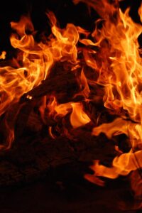 Close-up of a blazing bonfire with intense flames against a dark background.