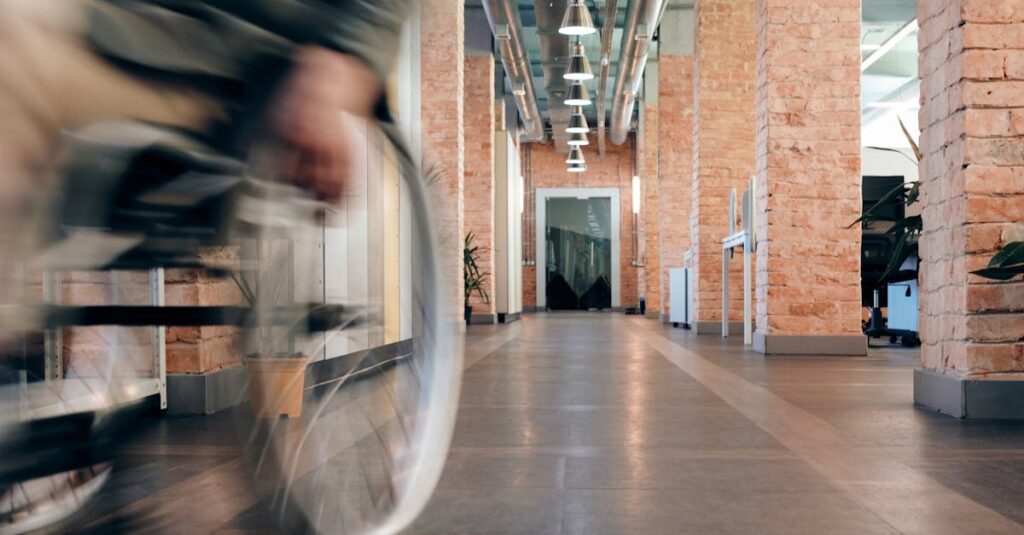 Blurred motion of wheelchair in a modern office hallway, highlighting accessibility.