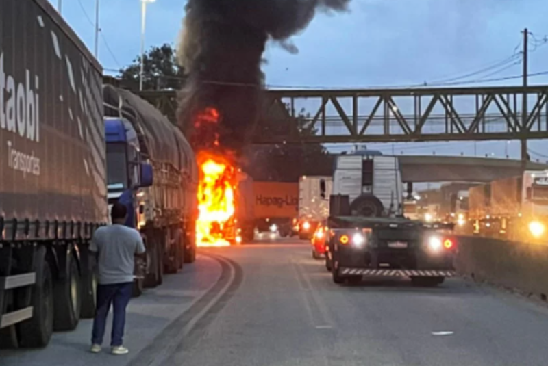 Um caminhão que transportava algodão pegou fogo no início da noite desta quinta-feira (2) no km 62 da Rodovia Anchieta, em Santos, no litoral de São Paulo. O incêndio atingiu a carreta que seguia no sentido Capital, próximo ao elevado de acesso à Zona Noroeste. Segundo a concessionária Ecovias, responsável pelo trecho, equipes de apoio foram acionadas imediatamente, junto com a Polícia Militar Rodoviária (PMRv) e o Corpo de Bombeiros. Para o atendimento à ocorrência, a faixa 1 precisou ser interditada, mas o tráfego não chegou a registrar congestionamento. O Corpo de Bombeiros informou que enviou cinco viaturas ao local para controlar as chamas. O trabalho de combate ao fogo foi concentrado também na Avenida Marginal Direita da Anchieta. De acordo com a corporação, ninguém ficou ferido. As causas do incêndio ainda não foram divulgadas.