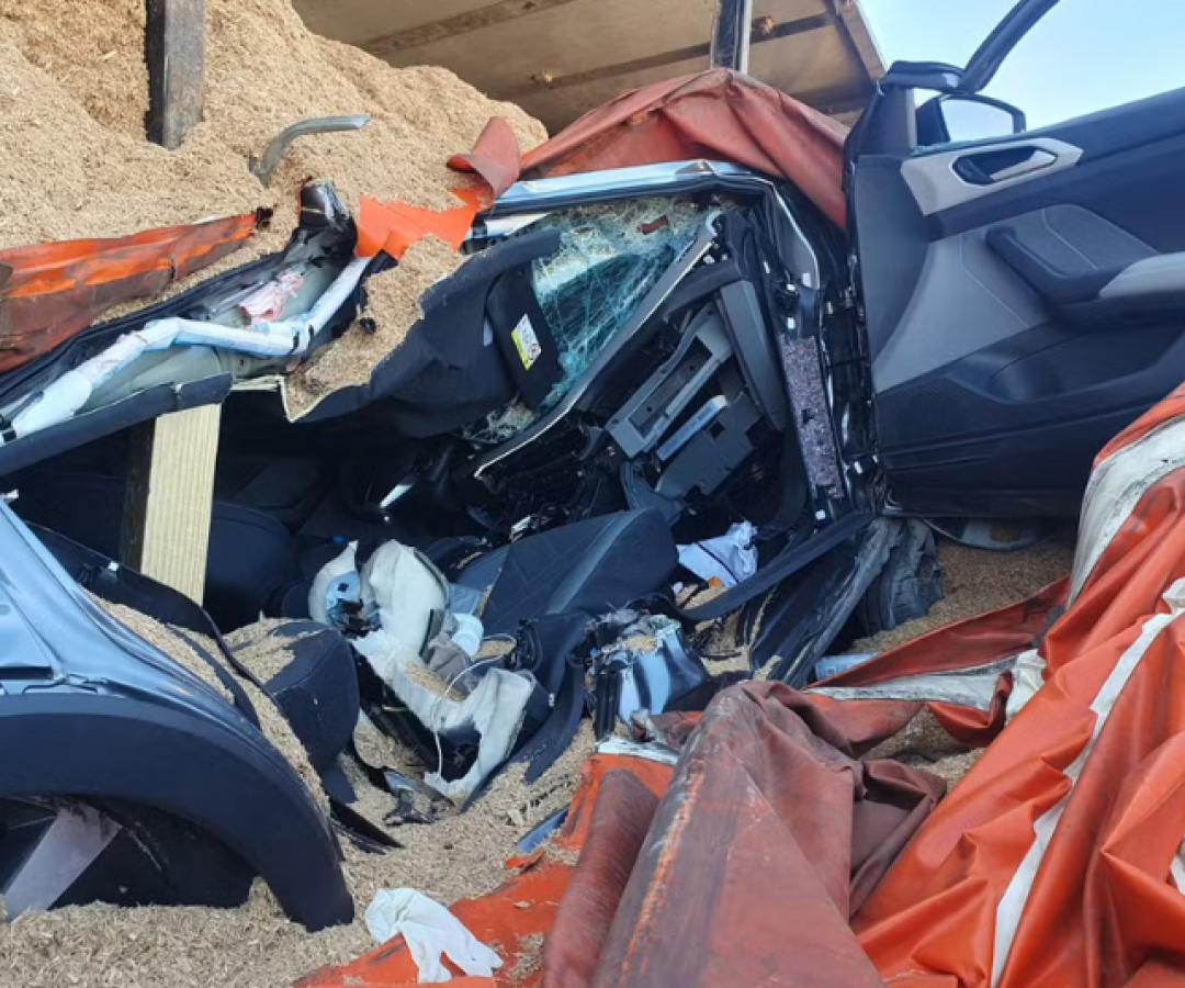 O acidente ocorreu na alça de acesso à BR-448, onde a carreta, que transportava serragem, tombou e caiu sobre o carro da vítima.