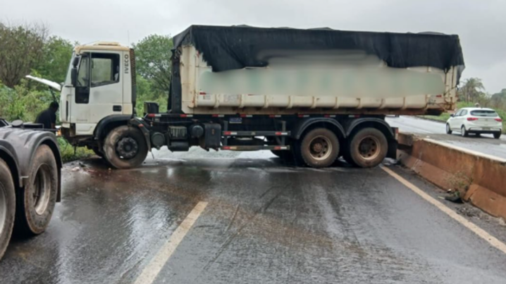 Caminhão roda em pista molhada e atinge mureta na BR-354